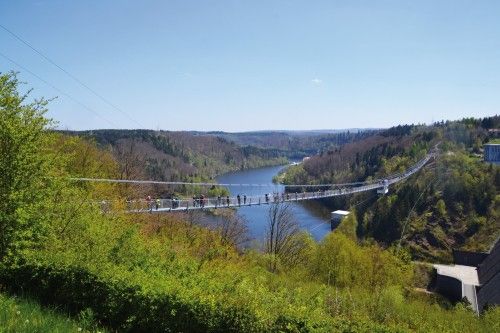 Hängebrücke über eine bewaldete Schlucht mit Fluss